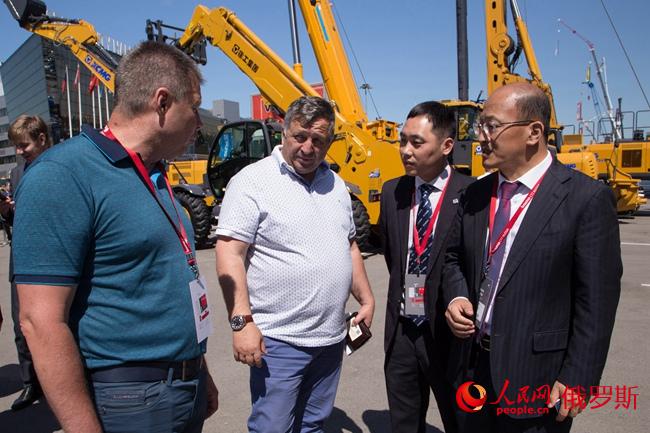 徐工機(jī)器副總裁、徐工團(tuán)體收支口公司總司理劉建森向俄經(jīng)銷商先容設(shè)備（右一）（實習(xí)生 陳效坤 攝）
